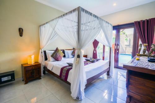 a bedroom with a bed with a canopy at Pondok DEWI Villa - LEGIAN - 6 Bedroom Villa - Great Location in Legian