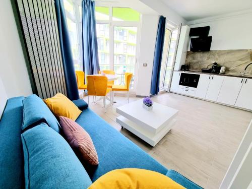 sala de estar con sofá azul y mesa en Beach Resort Studio Fitness-spa-pool, en Mamaia Nord – Năvodari