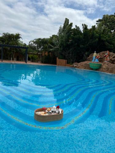 a swimming pool with a toy boat in the water at Vijayshree Resort, Hampi in Hampi
