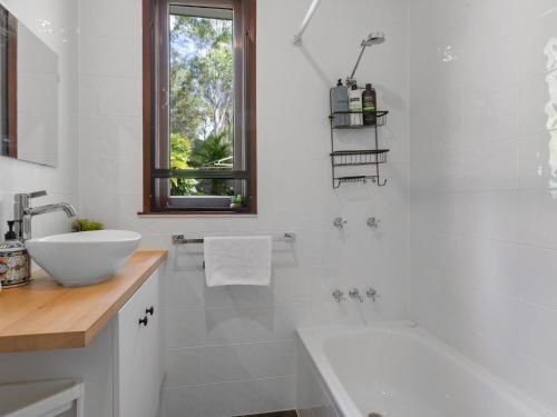 a white bathroom with a sink and a tub at Great value 3BD house at a convenient location in Brisbane