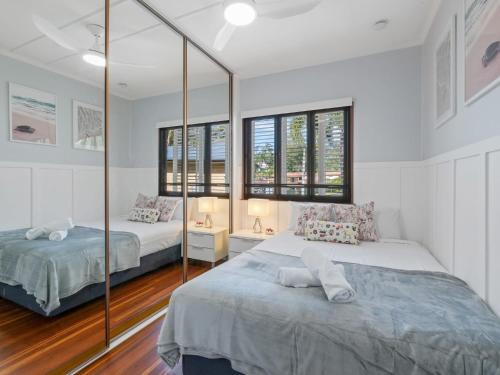 a bedroom with two beds and a mirror at Great value 3BD house at a convenient location in Brisbane