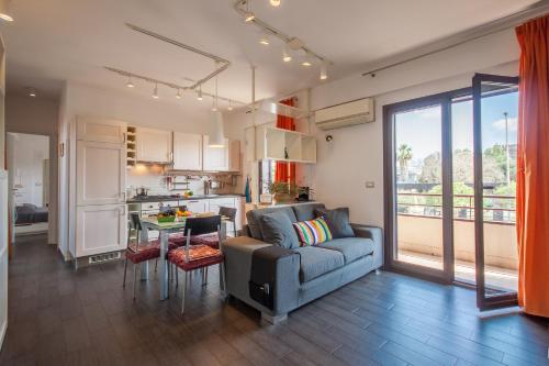 Vicerè Apartment With AC and Wi-Fi - Happy Rentals في كاتانيا: غرفة معيشة ومطبخ مع أريكة وطاولة