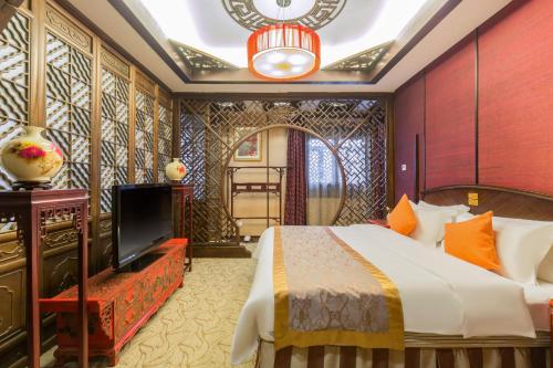 een hotelkamer met een bed en een televisie bij Jianguo Hotspring Hotel in Beijing