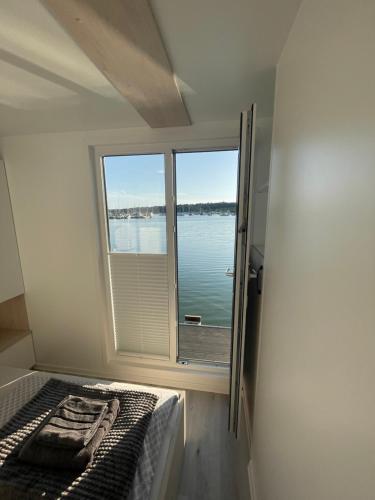 a bedroom with a bed and a window with a view of the water at Floating sea house - PULA 1 in Pula