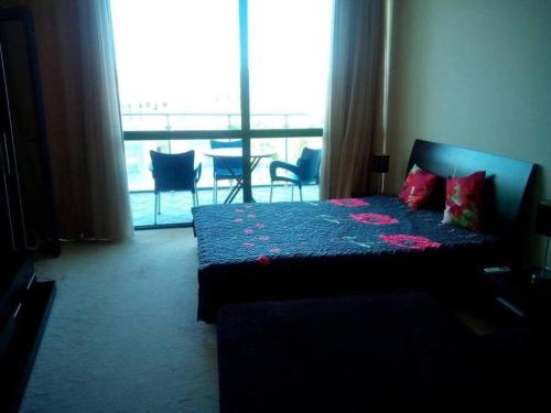a bedroom with a bed and a large window at Studio in Primorsko del Sol in Primorsko