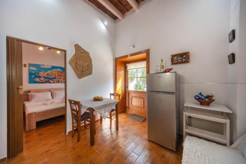 een keuken met een tafel en een koelkast en een slaapkamer bij Seascape Krithoni in Agia Marina