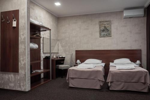 a hotel room with two beds and a desk at Optima Collection Gallery Poltava in Poltava