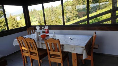 une table à manger avec des chaises et une grande fenêtre dans l'établissement Cabana belvedere (VIS), à Colibiţa