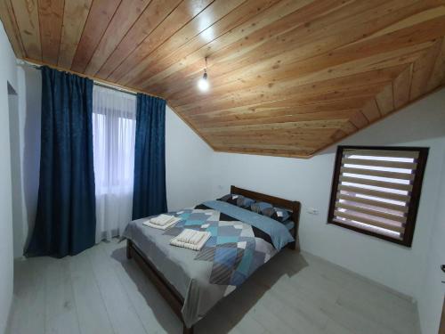 - une chambre avec un lit et un plafond en bois dans l'établissement Cabana belvedere (VIS), à Colibiţa
