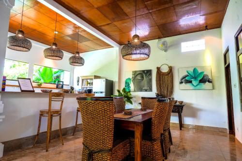 a dining room with a table and chairs and pendant lights at Villa MONTI - LEGIAN - SEMINYAK - Lovely 2 Bedroom Villa - Great Location ! in Seminyak