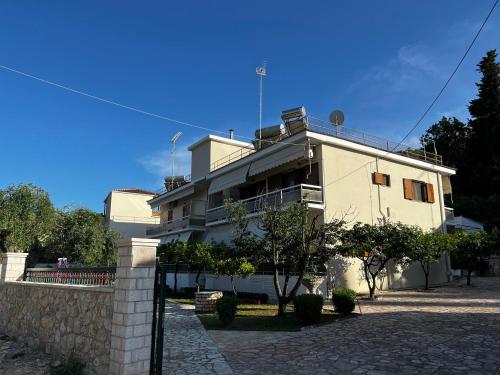 a white building with a fence in front of it at Dionysus Sivota Center in Sivota