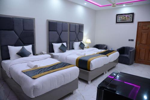 a hotel room with two beds and a couch at GO Luxury Grand Hotel in Lahore