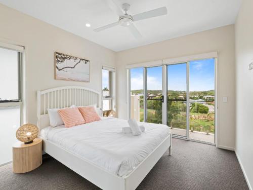 a white bedroom with a large bed and windows at Luxury Hilltop Brand-New 5BD Holiday Home in Brisbane