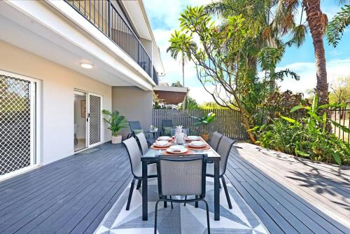 a dining table and chairs on a deck at Tropical Allure - A Tranquil Fannie Bay Oasis in Darwin