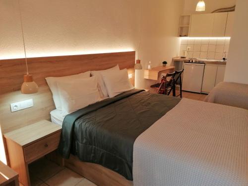 a bedroom with a large bed and a kitchen at Villa Dafni Studios in Limenas