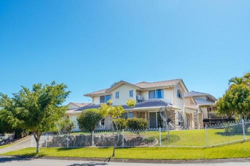 a house with a fence in front of a street at Spacious newly redecorated 5BD Family Home in Brisbane