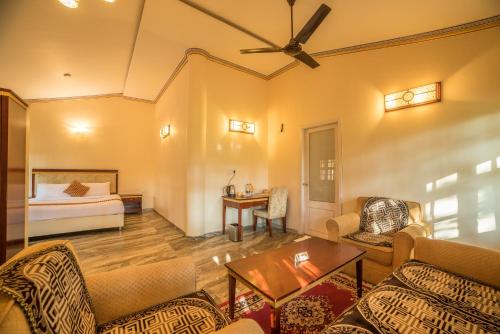 a living room with a bed and a couch at Vijayshree Resort, Hampi in Hampi
