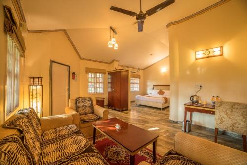 a living room with a bed and a couch and a table at Vijayshree Resort, Hampi in Hampi