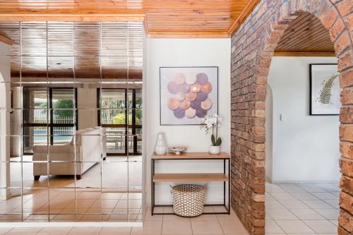 an archway leads into a living room with a brick wall at Hobbit House Inspired 4BR cozy Fairytale Cottage in Brisbane