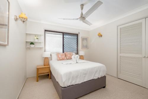a white bedroom with a bed and a window at Hobbit House Inspired 4BR cozy Fairytale Cottage in Brisbane