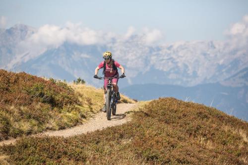 a person riding a bike on a mountain trail at Harmls Aparthotel in Flachau