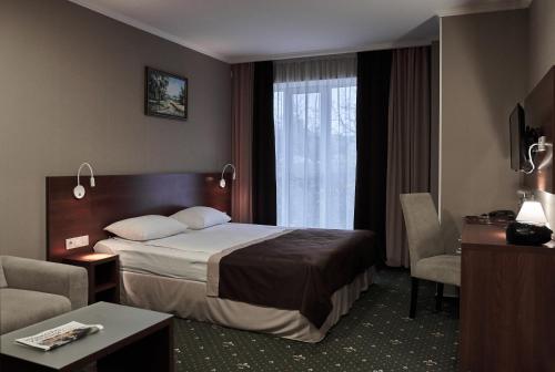 a hotel room with a bed and a window at Optima Collection Gallery Poltava in Poltava