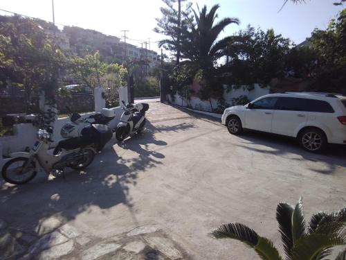 a motorcycle and a car parked in a parking lot at Villa Ourania in Troulos