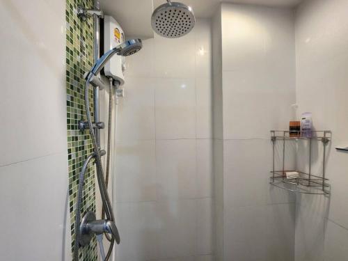 La salle de bains est pourvue d'une douche avec un pommeau de douche. dans l'établissement Plus2 Condo by Khun Opor, à Ban Thung Thong