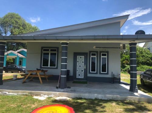 una pequeña casa con un frisbee en el patio en Rasa Sayang Homestay Mersing en Mersing