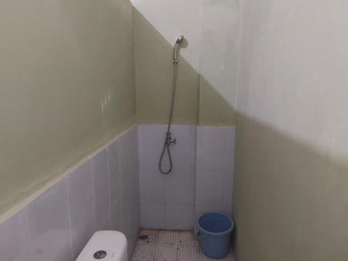 y baño pequeño con aseo y ducha. en OYO 92644 Onong's Homestay en Tomohon
