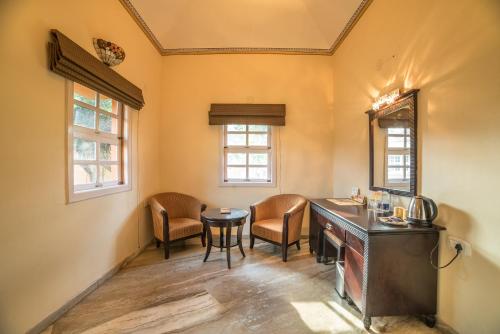 a room with a table and chairs and windows at Vijayshree Resort, Hampi in Hampi