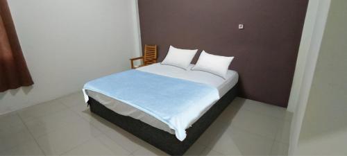 1 dormitorio con 1 cama grande con manta azul en OYO 92659 Wisma Deli Syariah, en Pangkajene