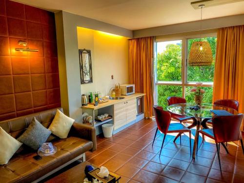 a living room with a couch and a table with chairs at Sino House Phuket Hotel - SHA Plus in Phuket Town