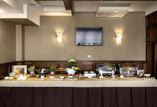 a buffet table with food and a flat screen tv at Kamelot in Ternopilʼ