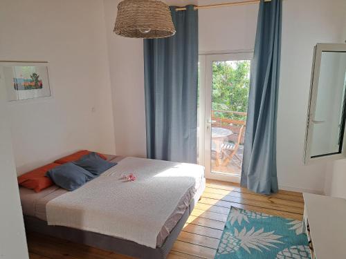 una camera da letto con un letto e una porta su un patio di La belle Cabane a Saint-Leu