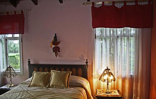 a bedroom with a bed and two windows at Hostal Saint Mary´s Tababela in Tababela