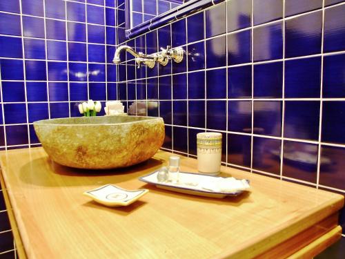 baño con encimera con fregadero y azulejos azules en L'Una di Notte, en Salerno