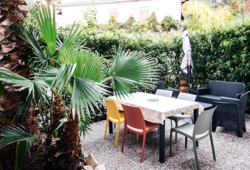 a patio with a table and chairs and palm trees at Taormina Argo Apartment by Taormina Holidays in Taormina