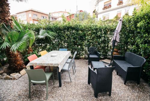 a patio with a table and chairs and a hedge at Taormina Argo Apartment by Taormina Holidays in Taormina
