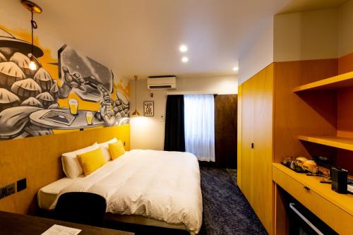 a bedroom with a bed and a painting on the wall at The Villa & Barrel Lounge in Shizuoka