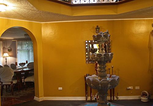 a room with a dining room with a yellow wall at Hostal Saint Mary´s Tababela in Tababela