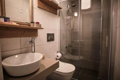 a bathroom with a sink and a toilet and a shower at Ayvalık Palacitta Guesthouse in Ayvalık