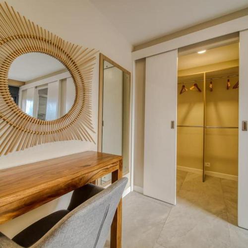 sypialnia z lustrem i drewnianym stołem w obiekcie Amadria La Saline Les Bains - 5 étoiles w mieście La Saline Les hauts 
