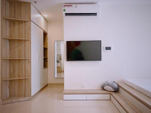ein Schlafzimmer mit einem Flachbild-TV an der Wand in der Unterkunft BOBO HOMESTAY in Ða Tốn