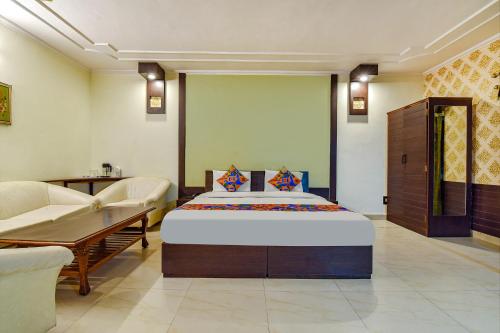 a bedroom with a bed and a couch and a table at FabHotel Prime Surpin Palace in Kota