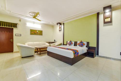 1 dormitorio con cama, mesa y sofá en FabHotel Prime Surpin Palace, en Kota