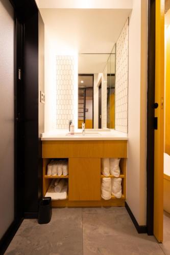 a bathroom with a sink and a mirror at The Villa & Barrel Lounge in Shizuoka