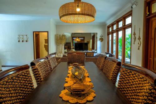 een eetkamer met een houten tafel en stoelen bij Villa MARIE - KUTA - 6 Bedroom 4 Bathroom Villa - Great Location ! in Kuta