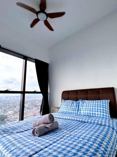 a bed with towels on it with a ceiling fan at Family Gathering with Bathtub in Icon City, 12 Pax near Bandar Sunway in Petaling Jaya
