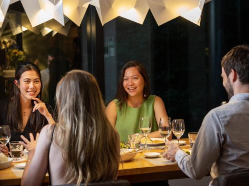 a group of people sitting around a table in a restaurant at AYA Villa in Kutchan